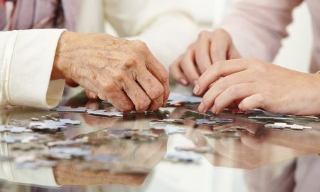 Senior Citizen Hands - solving a jigsaw puzzle